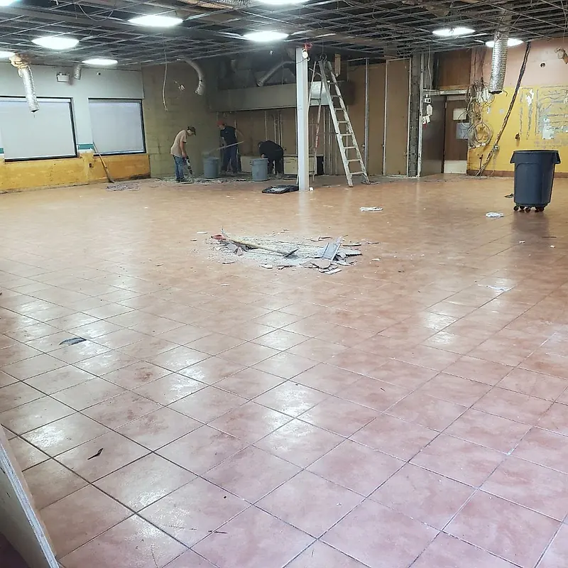 Large empty restaurant dining room with ceramic tile floor and the ceiling grid open