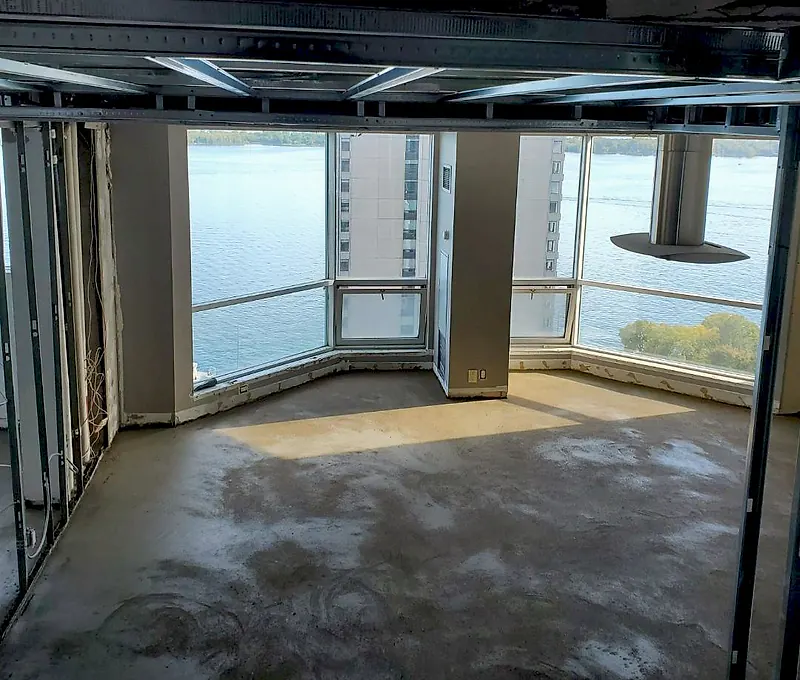 Finished mortar floor bed in a corner condo room with floor-to-ceiling windows and a lake view